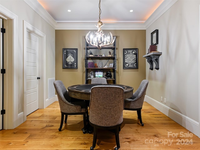 dining area featuring a chandelier, wood-type flooring, and ornamental molding