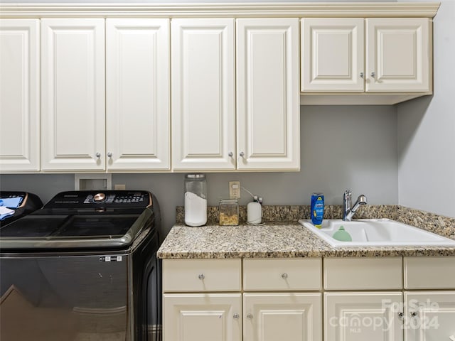 clothes washing area featuring hookup for a washing machine, sink, and cabinets