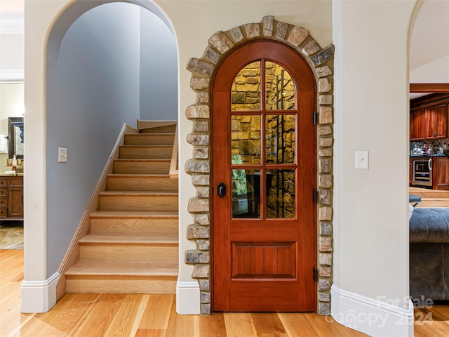 entrance foyer with wine cooler and light hardwood / wood-style flooring