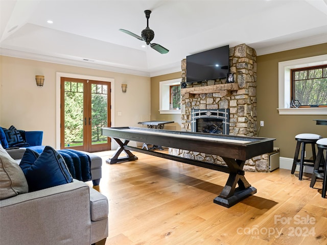 rec room featuring light wood-type flooring, a raised ceiling, plenty of natural light, and ceiling fan