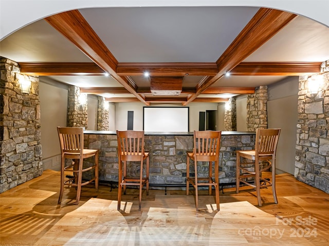 bar with beam ceiling, light hardwood / wood-style floors, and coffered ceiling