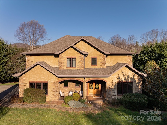 view of front of home with a porch and a front lawn