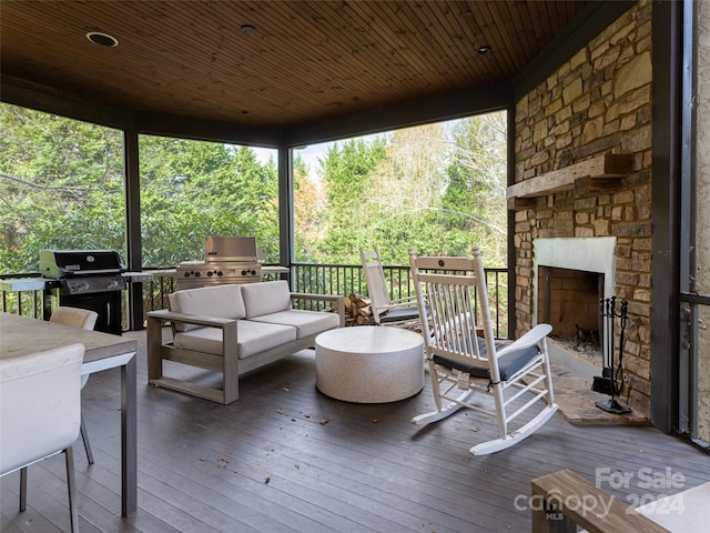 wooden terrace with an outdoor living space with a fireplace and area for grilling