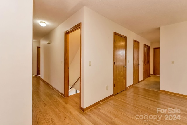 corridor with wood-type flooring and a textured ceiling