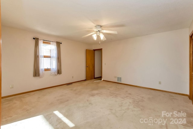 empty room with light colored carpet and ceiling fan