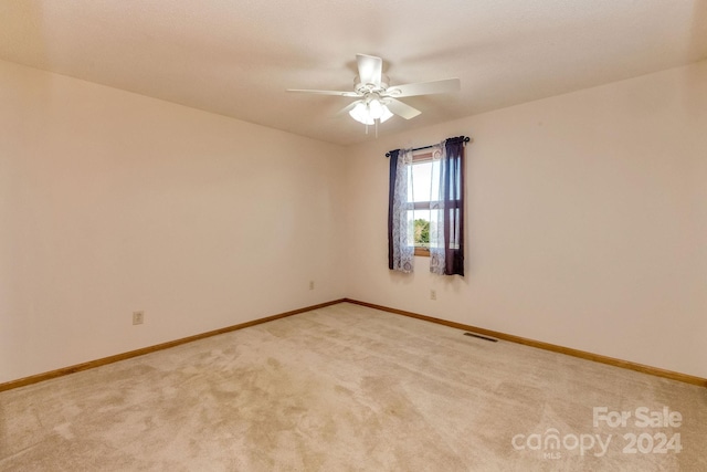 carpeted spare room featuring ceiling fan