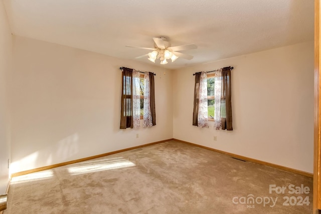 carpeted empty room featuring ceiling fan