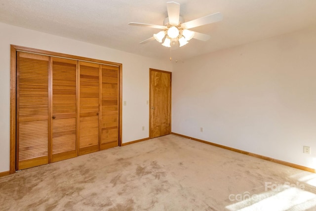 unfurnished bedroom with ceiling fan, a closet, and light carpet