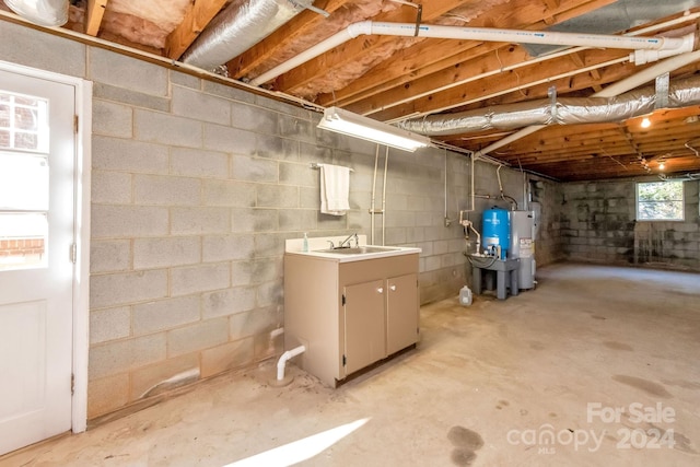 basement with electric water heater and sink