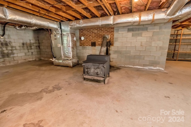 basement featuring a wood stove and heating unit