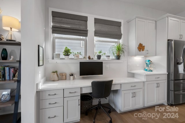 office featuring hardwood / wood-style floors and built in desk