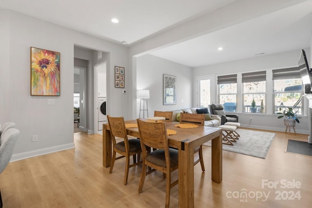 dining space with light hardwood / wood-style floors and washer / dryer