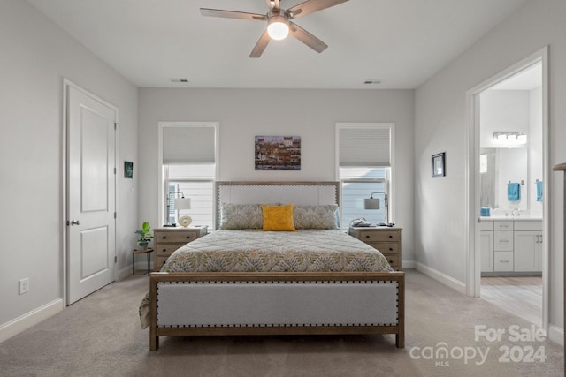 carpeted bedroom with connected bathroom, ceiling fan, and sink