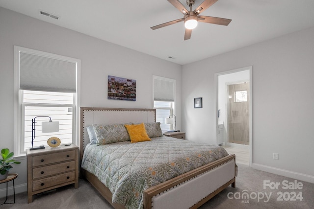 bedroom featuring connected bathroom, ceiling fan, and light colored carpet