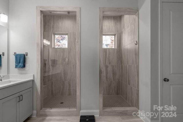 bathroom with vanity and a tile shower