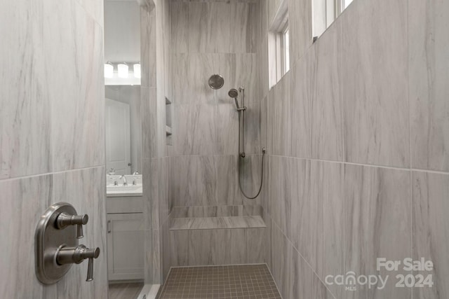 bathroom with vanity and tiled shower