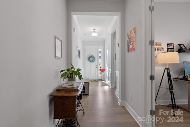 corridor featuring ornamental molding and hardwood / wood-style flooring