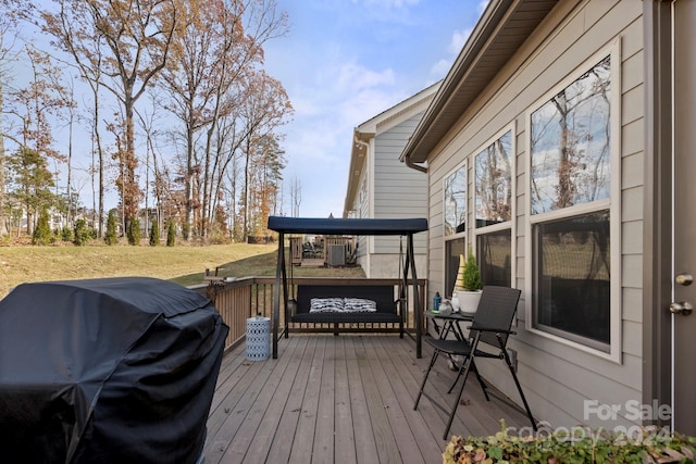 wooden deck with central AC unit and area for grilling