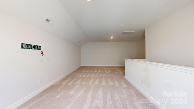 bonus room featuring light colored carpet and vaulted ceiling