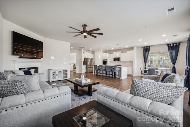 living room with ceiling fan and wood-type flooring