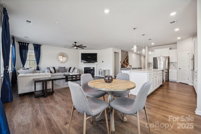 dining room with wood-type flooring, ceiling fan, and sink