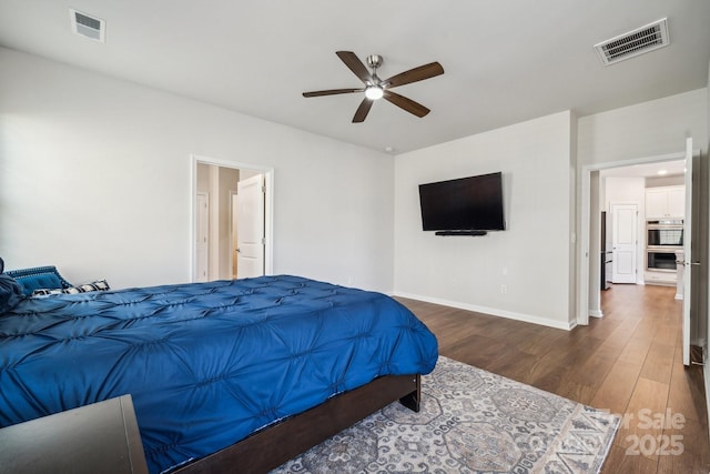 bedroom with dark hardwood / wood-style flooring, fridge, and ceiling fan