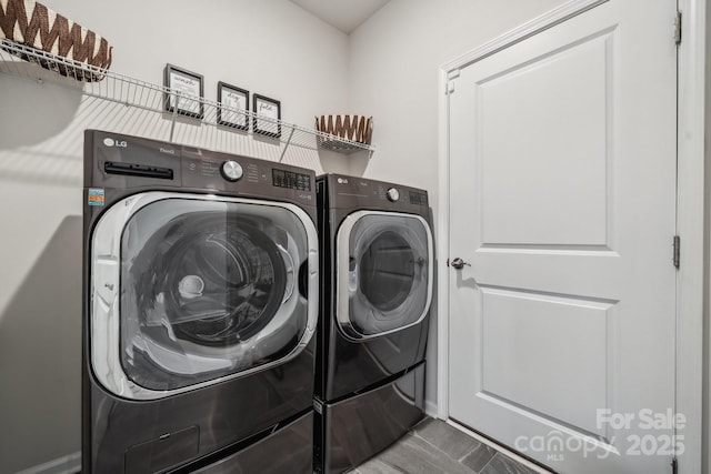 clothes washing area featuring tile patterned floors and washer and dryer