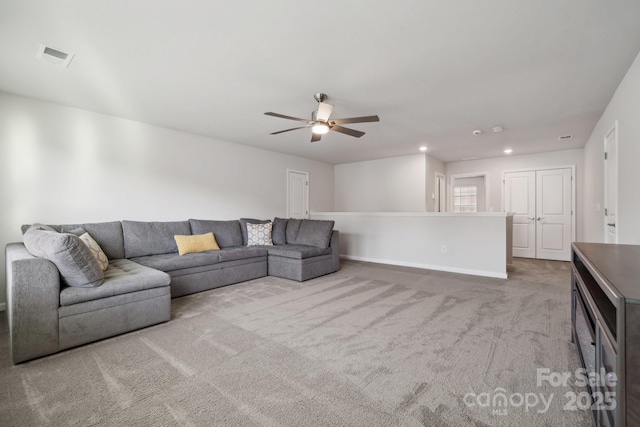 carpeted living room with ceiling fan