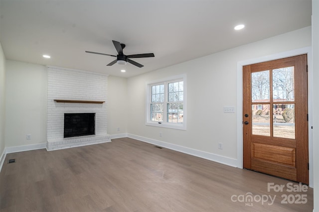 unfurnished living room featuring hardwood / wood-style flooring, a fireplace, and ceiling fan