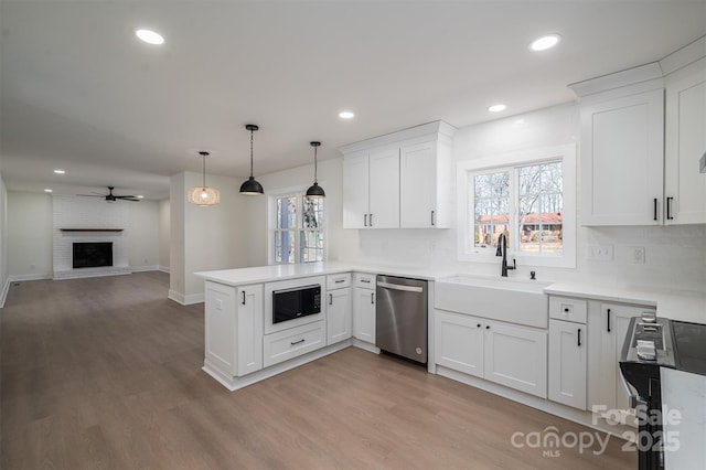 kitchen with white cabinetry, stainless steel appliances, decorative light fixtures, and kitchen peninsula