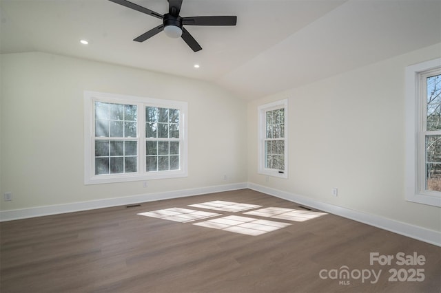 spare room with vaulted ceiling, plenty of natural light, and dark wood-type flooring