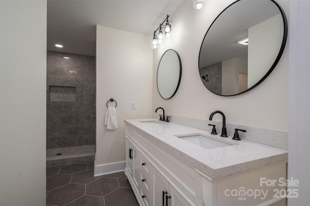 bathroom with vanity, tiled shower, and tile patterned floors