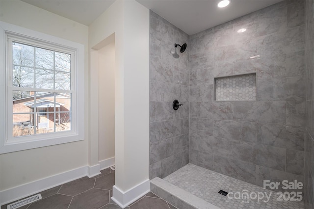 bathroom featuring tiled shower and tile patterned flooring