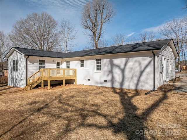 back of property with a wooden deck and a lawn