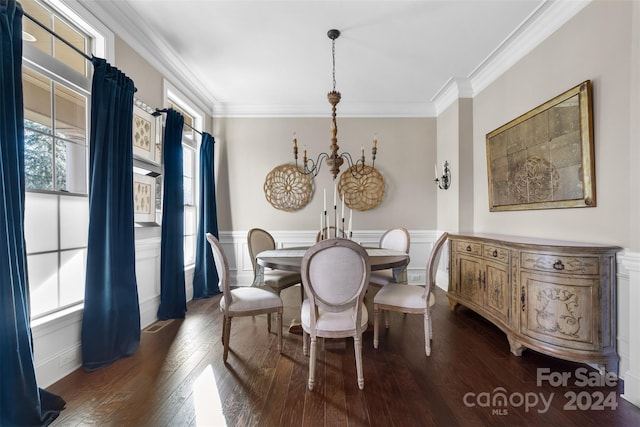 dining room featuring crown molding, dark hardwood / wood-style floors, and an inviting chandelier