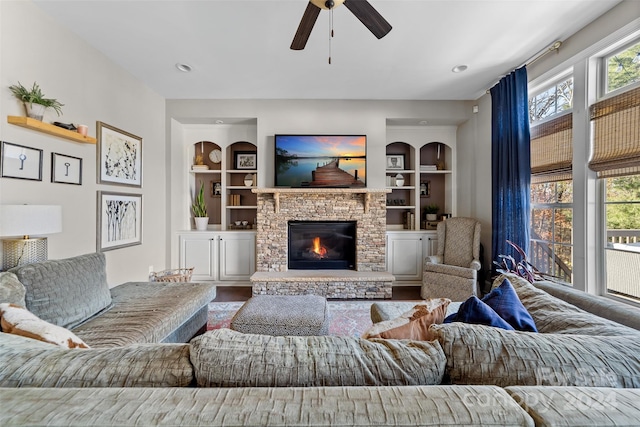 living room featuring built in shelves, a fireplace, and a healthy amount of sunlight