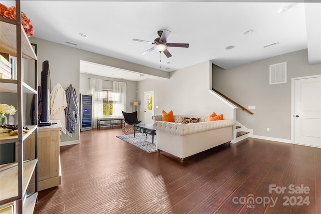 living room with ceiling fan and dark hardwood / wood-style flooring