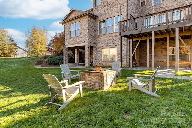 rear view of property with a yard, a patio, a fire pit, and a deck