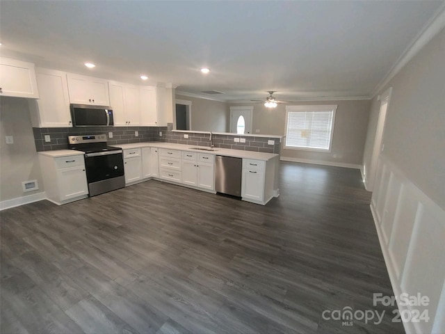 kitchen featuring white cabinets, ornamental molding, stainless steel appliances, and dark wood-type flooring