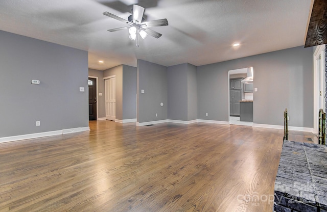 living room with ceiling fan, dark wood-type flooring, and a textured ceiling