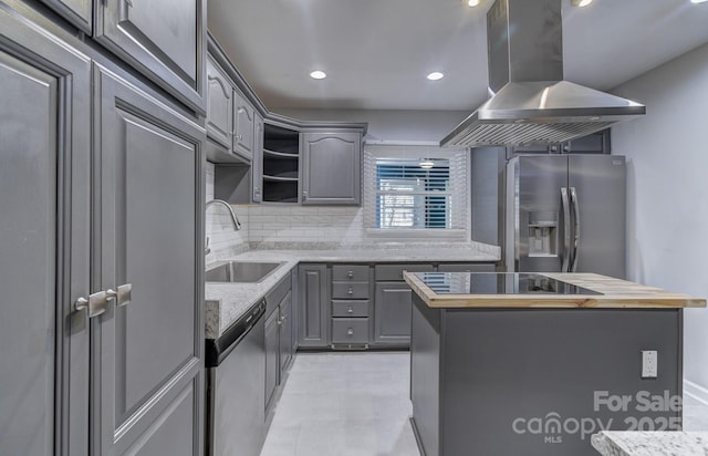 kitchen featuring island exhaust hood, gray cabinets, stainless steel appliances, and wood counters