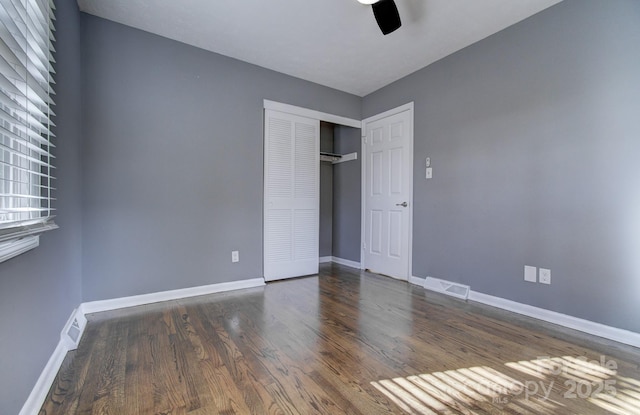 unfurnished bedroom with ceiling fan, a closet, and dark hardwood / wood-style floors