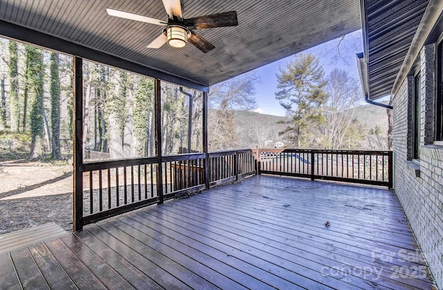 wooden deck with ceiling fan and a mountain view