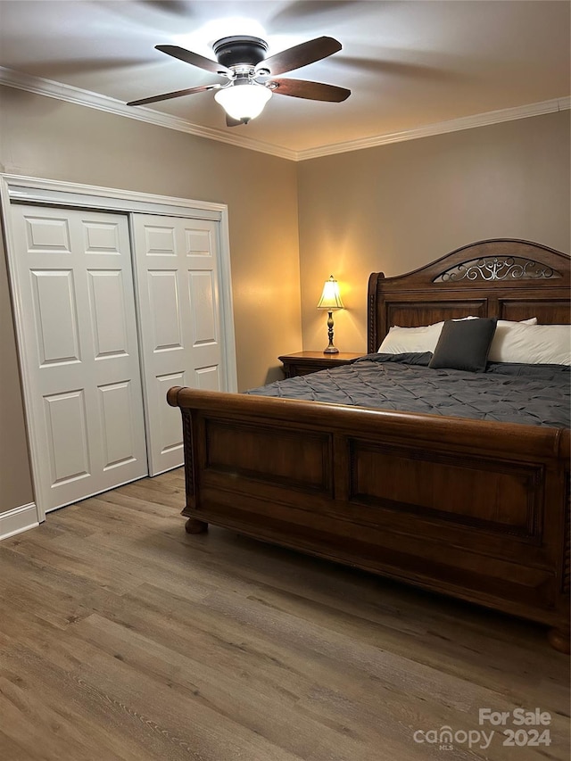 bedroom featuring ceiling fan, wood-type flooring, crown molding, and a closet