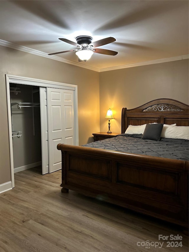 bedroom featuring hardwood / wood-style floors, a closet, ceiling fan, and crown molding