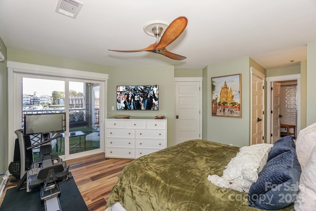 bedroom featuring ceiling fan, visible vents, wood finished floors, and access to exterior