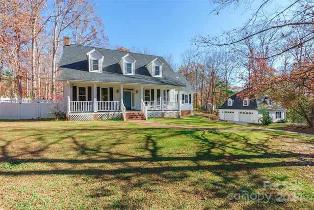 new england style home featuring covered porch, a garage, an outdoor structure, and a front yard