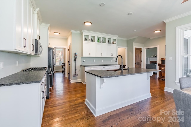 kitchen with sink, dark hardwood / wood-style flooring, a center island with sink, white cabinets, and appliances with stainless steel finishes