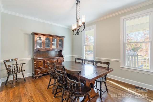 dining area featuring a chandelier, dark hardwood / wood-style flooring, and crown molding