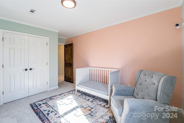 carpeted bedroom featuring crown molding and a closet